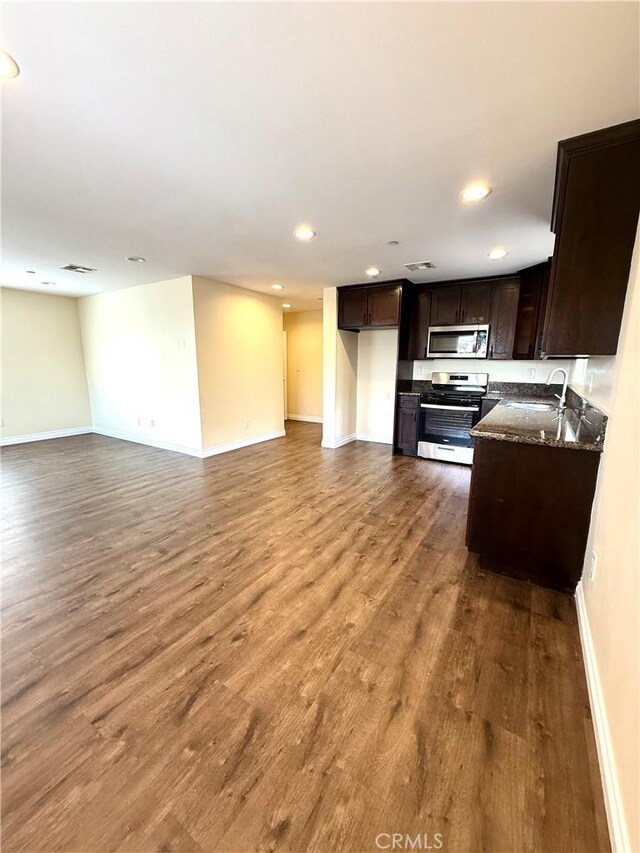 645 E 78th St, Los Angeles, CA 90001 - kitchen with stainless steel appliances, recessed lighting, dark brown cabinets, wood finished floors, and open floor plan