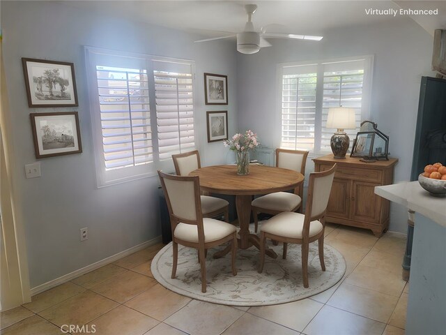 dining room featuring light tile patterned floors, a healthy amount of sunlight, baseboards, and a ceiling fan