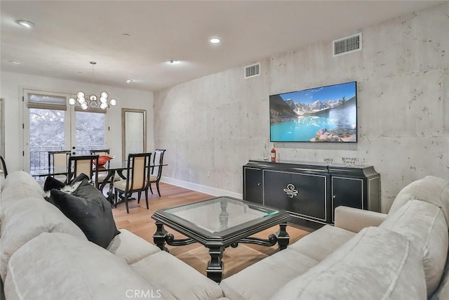 living room with wood finished floors, visible vents, recessed lighting, and a chandelier