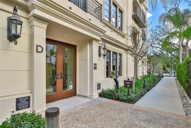 doorway to property featuring stucco siding and french doors