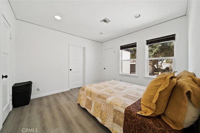bedroom featuring recessed lighting, visible vents, baseboards, and wood finished floors