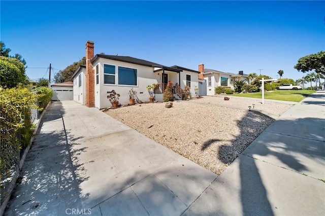 view of front of home featuring a chimney and stucco siding
