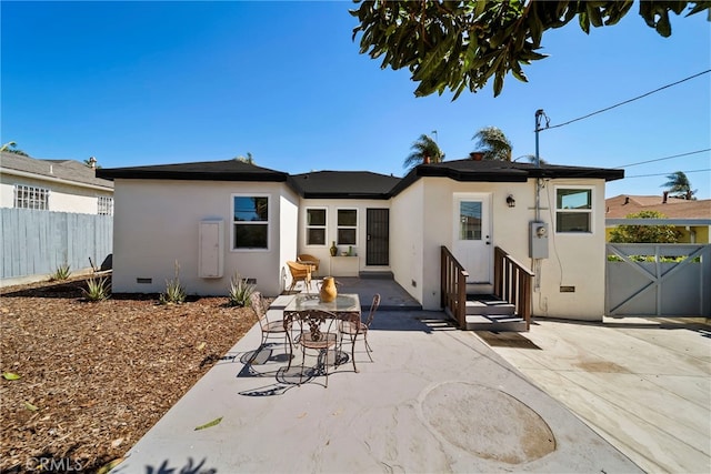 rear view of property with fence, a patio, crawl space, and stucco siding