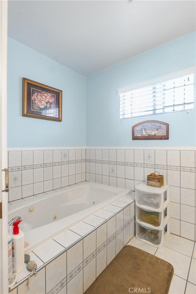 bathroom featuring tile patterned floors, tile walls, and a whirlpool tub