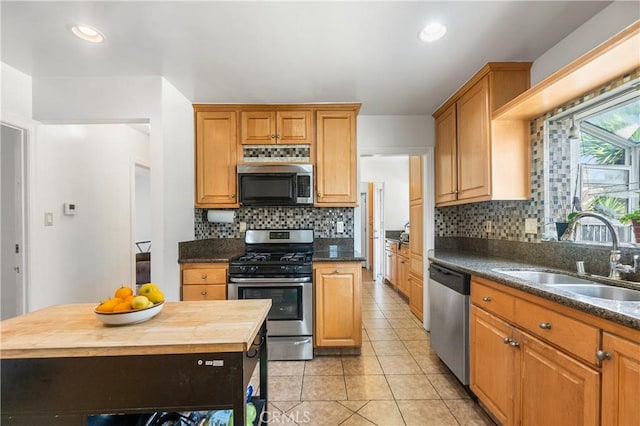 kitchen featuring backsplash, light tile patterned floors, recessed lighting, stainless steel appliances, and a sink