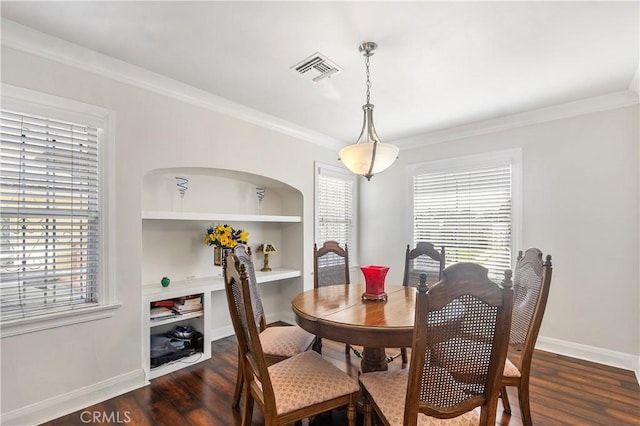 dining area with built in features, a healthy amount of sunlight, dark wood-style flooring, and ornamental molding