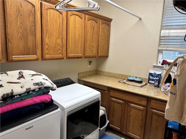 clothes washing area with cabinet space and independent washer and dryer