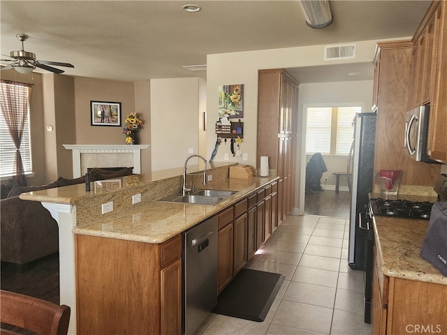 kitchen featuring a sink, a peninsula, stainless steel appliances, visible vents, and ceiling fan