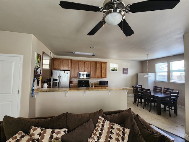 living area featuring light tile patterned floors and ceiling fan
