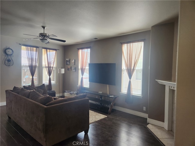 living area featuring baseboards, wood finished floors, and a ceiling fan