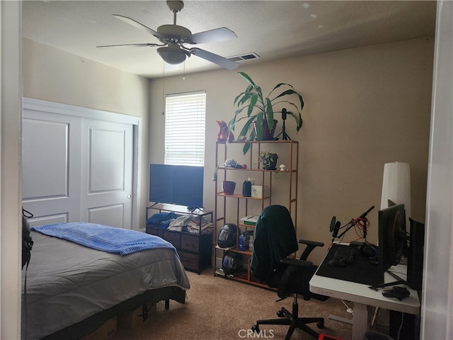 bedroom featuring visible vents, a closet, ceiling fan, and carpet