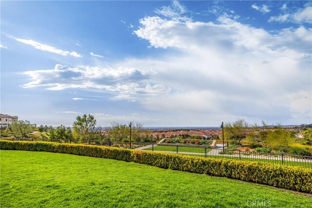 view of property's community with a yard and fence