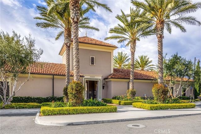 mediterranean / spanish-style home with stucco siding and a tile roof