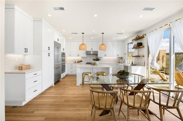 dining area with recessed lighting, light wood-style floors, and visible vents
