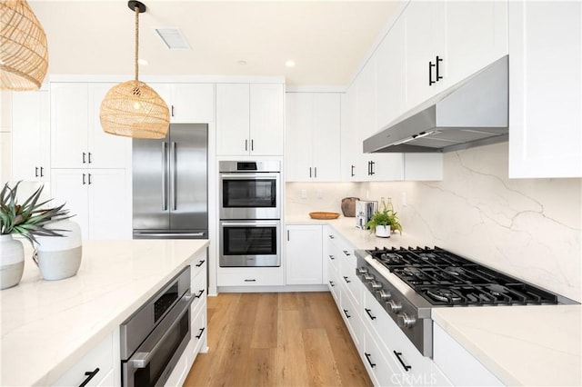kitchen featuring visible vents, under cabinet range hood, backsplash, white cabinetry, and appliances with stainless steel finishes