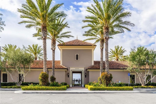 mediterranean / spanish-style house featuring a tile roof and stucco siding