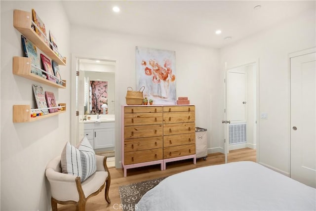 bedroom with visible vents, recessed lighting, ensuite bathroom, and wood finished floors