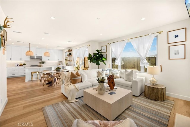 living room with visible vents, recessed lighting, light wood-style floors, and baseboards