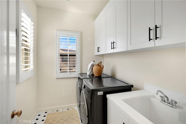 washroom with washing machine and clothes dryer, cabinet space, a wealth of natural light, and a sink