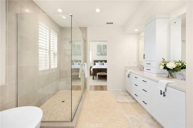 bathroom featuring visible vents, a walk in shower, a freestanding bath, ensuite bathroom, and vanity