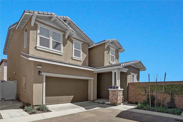 view of front of property with fence, a garage, driveway, and stucco siding