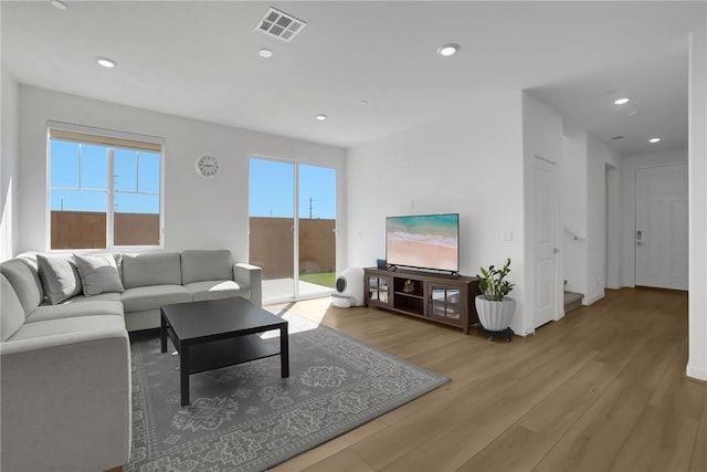 living room featuring recessed lighting, visible vents, and light wood-style flooring