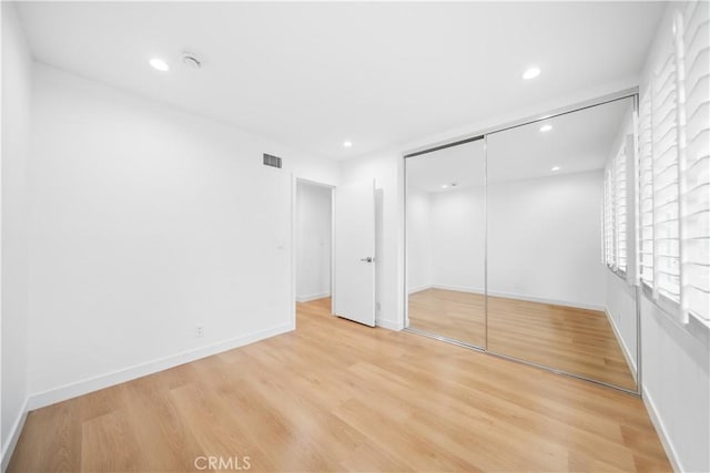 unfurnished bedroom featuring visible vents, baseboards, light wood-style flooring, recessed lighting, and a closet