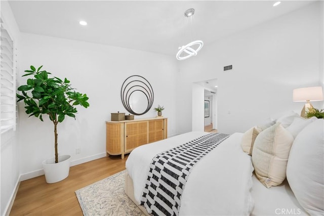 bedroom with visible vents, recessed lighting, light wood-style floors, baseboards, and a chandelier