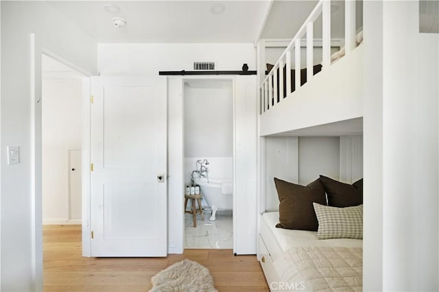 bedroom featuring wood finished floors and visible vents