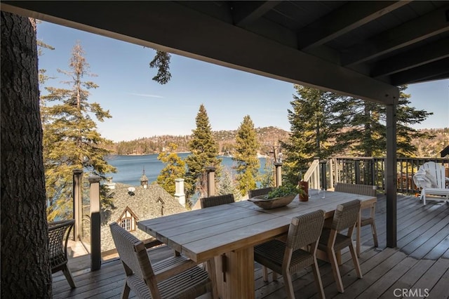 wooden deck with outdoor dining space and a water view
