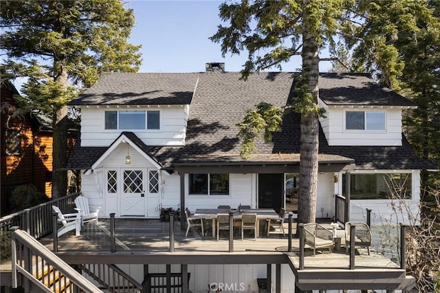 rear view of property with a wooden deck and a shingled roof