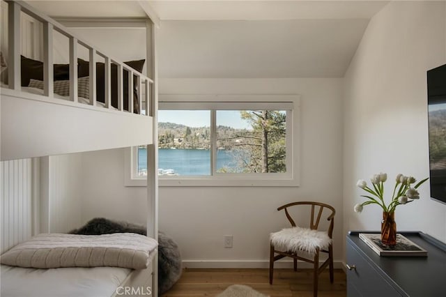 bedroom with baseboards, vaulted ceiling, and wood finished floors