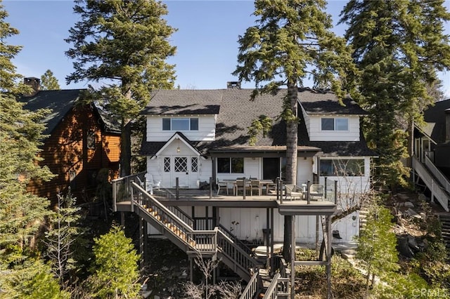 rear view of house featuring stairway and a deck