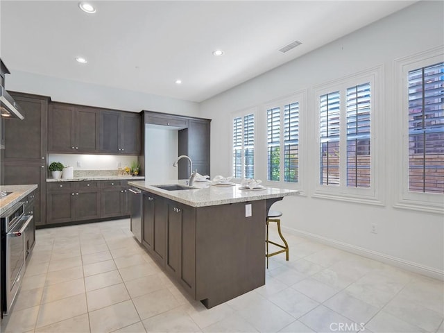 kitchen featuring recessed lighting, a sink, visible vents, dark brown cabinetry, and appliances with stainless steel finishes
