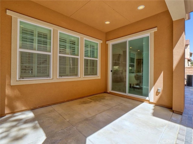 doorway to property featuring stucco siding and a patio