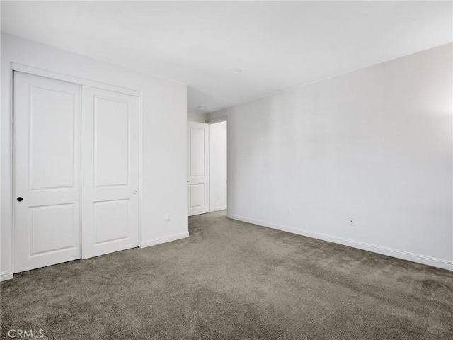 unfurnished bedroom with baseboards, a closet, and carpet