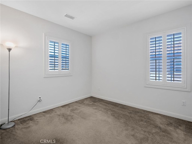 unfurnished room featuring baseboards, carpet flooring, and visible vents