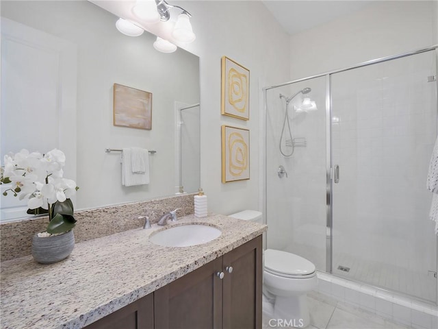 bathroom featuring toilet, a stall shower, and vanity
