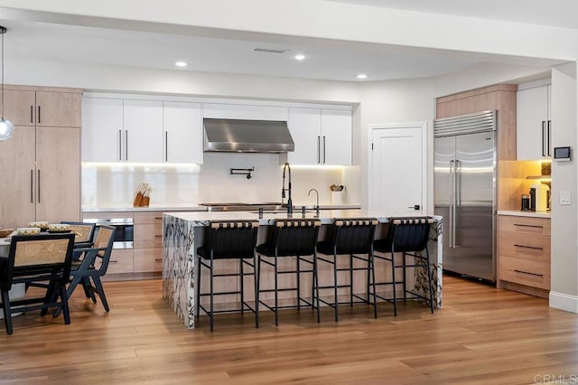 1452 Canoe Creek Way, Chula Vista, CA 91915 - kitchen featuring a kitchen bar, stainless steel appliances, light wood-type flooring, and extractor fan