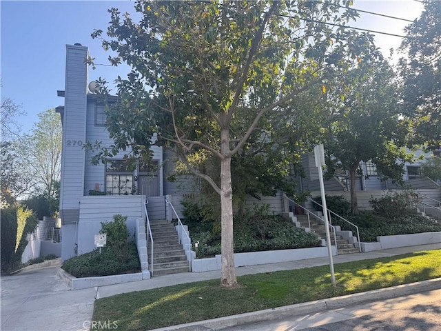 view of property hidden behind natural elements featuring stairs