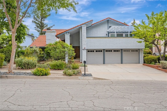 27072 Esward Dr, Calabasas, CA 91301 - view of front of house featuring a tiled roof, driveway, stucco siding, and a chimney
