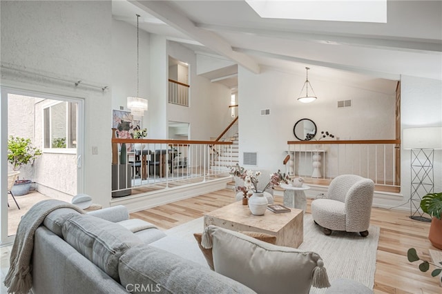 27072 Esward Dr, Calabasas, CA 91301 - living room with wood finished floors, stairway, beamed ceiling, high vaulted ceiling, and a skylight