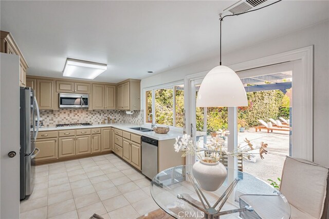 27072 Esward Dr, Calabasas, CA 91301 - kitchen featuring stainless steel appliances, a sink, light countertops, tasteful backsplash, and decorative light fixtures