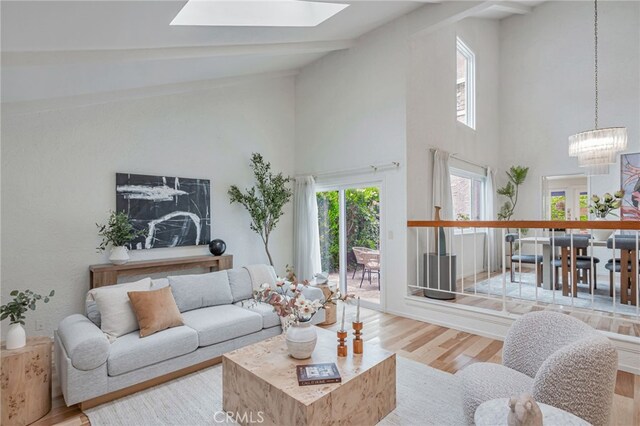 27072 Esward Dr, Calabasas, CA 91301 - living room with high vaulted ceiling, wood finished floors, a chandelier, and a skylight