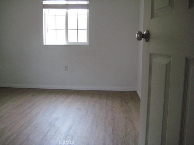 unfurnished room with baseboards and wood finished floors