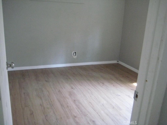 spare room with wood finished floors and baseboards