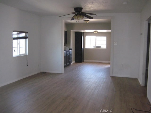 unfurnished living room featuring a healthy amount of sunlight, baseboards, light wood-style flooring, and a ceiling fan