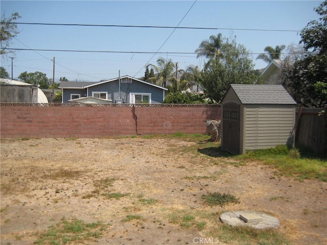 view of yard featuring an outdoor structure, a storage shed, and a fenced backyard