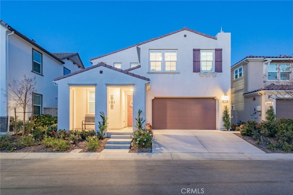 mediterranean / spanish house featuring stucco siding, a garage, concrete driveway, and a tiled roof