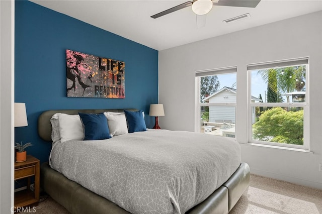 carpeted bedroom featuring baseboards, ceiling fan, and visible vents